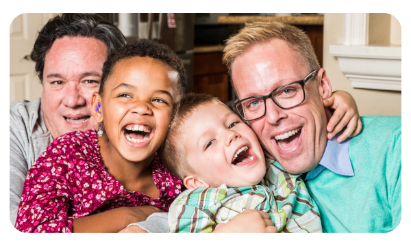 A family of four smiles at the camera