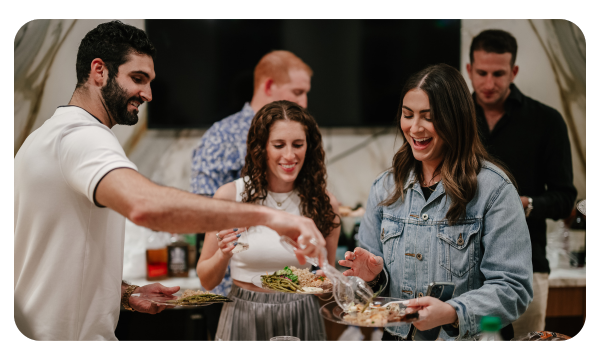 Three young adults sharing food at a social gathering